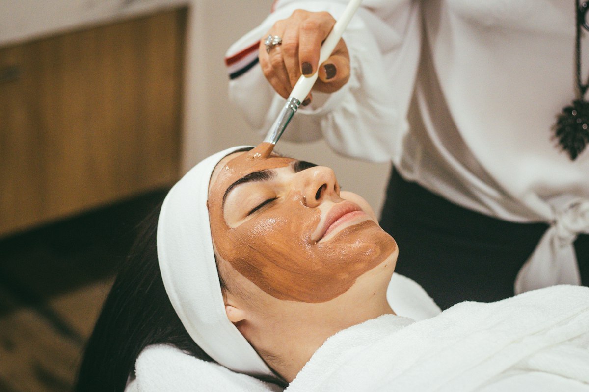 A clinician applying a gentle treatment to a patient’s face
