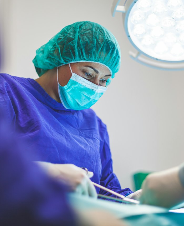 Nurse in surgical clothing concentrating on care
